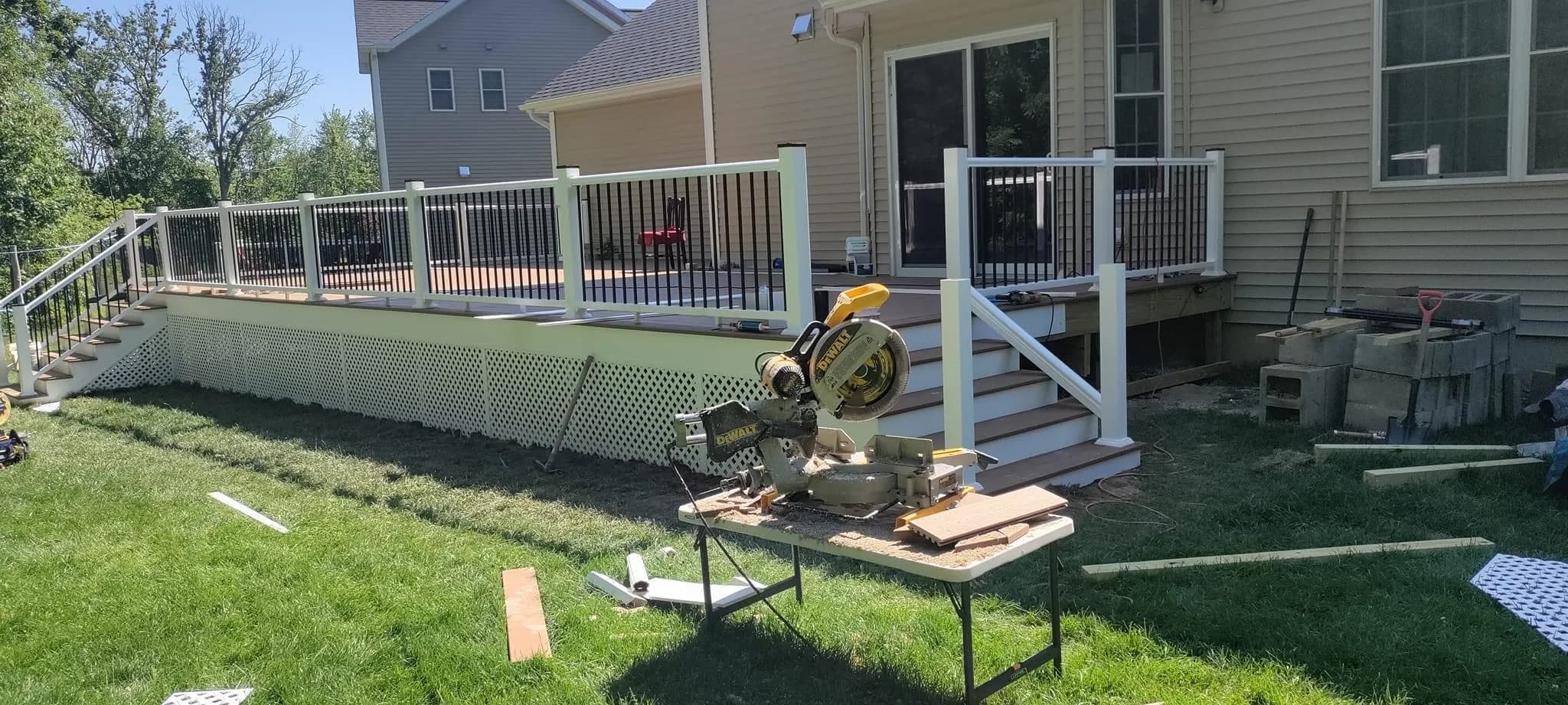 Deck with white rails, black balusters, and lattice skirt