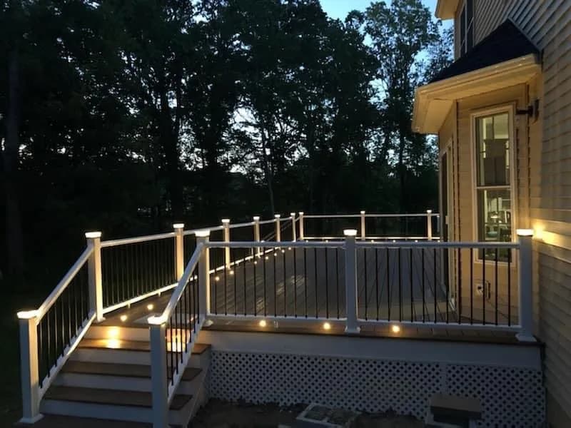 Lit deck stairs and white railings at twilight