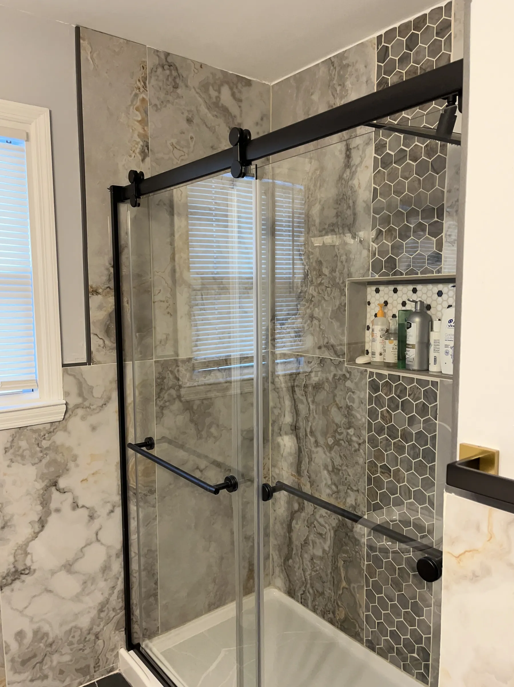 Marble walk-in shower with hexagonal tile accent