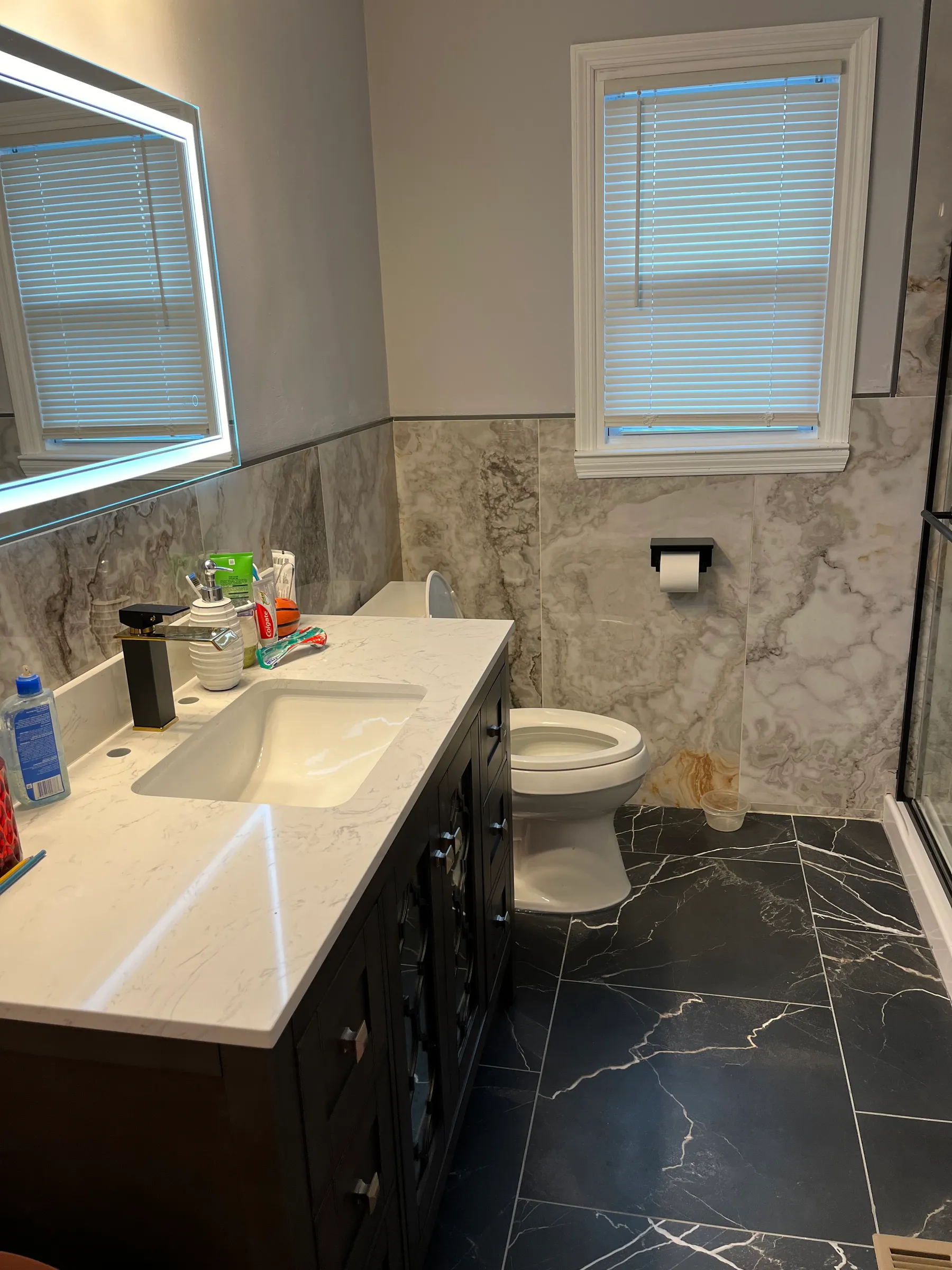 Bathroom remodel with marble walls and walk-in shower