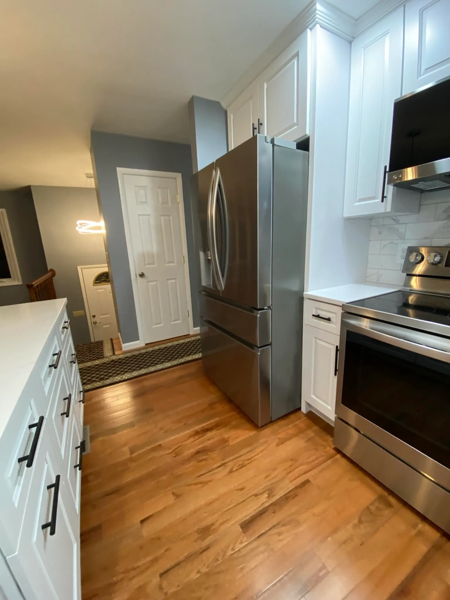 Kitchen corner with stainless fridge, range, and pantry door