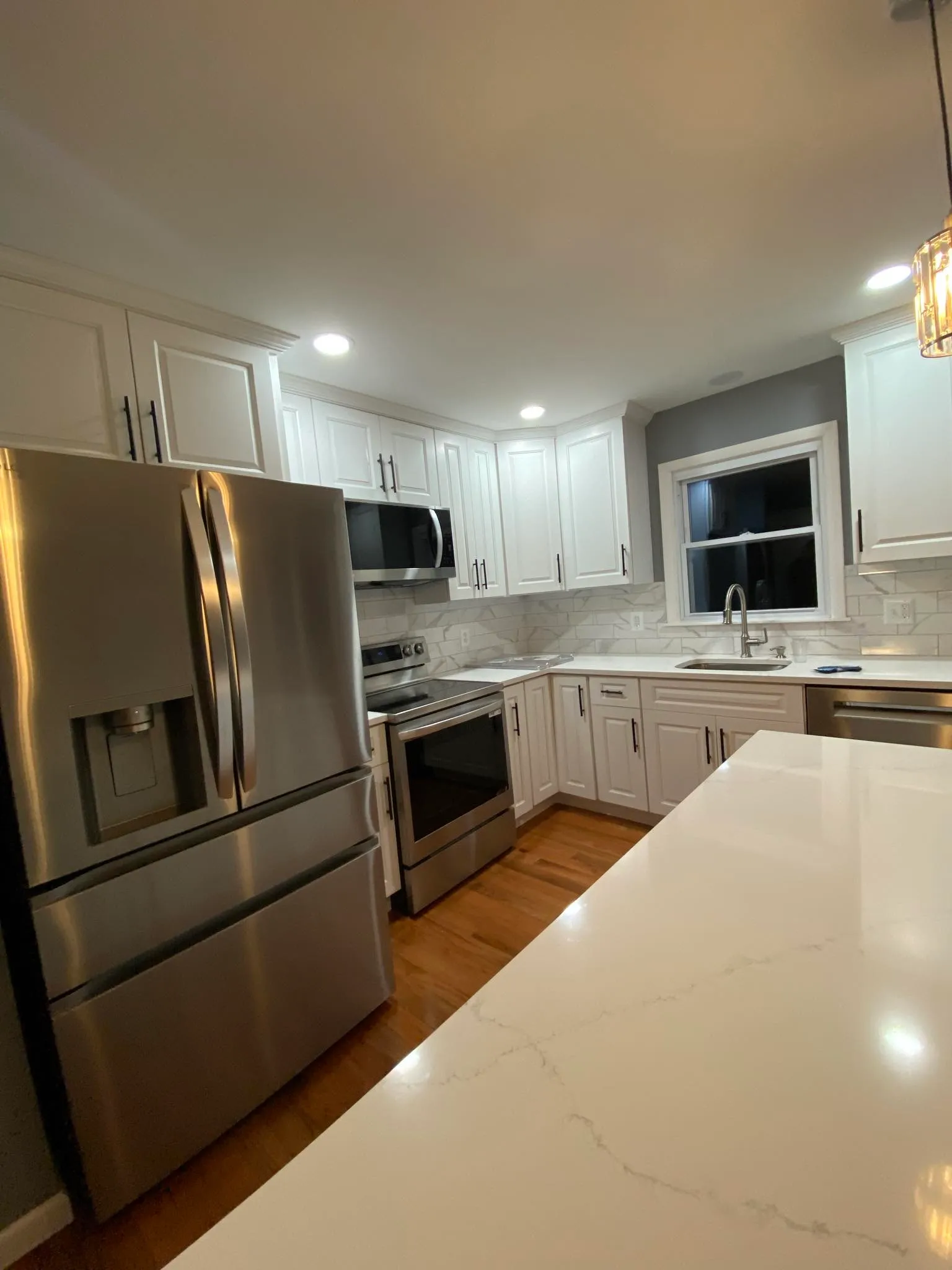Kitchen with stainless appliances and marble backsplash