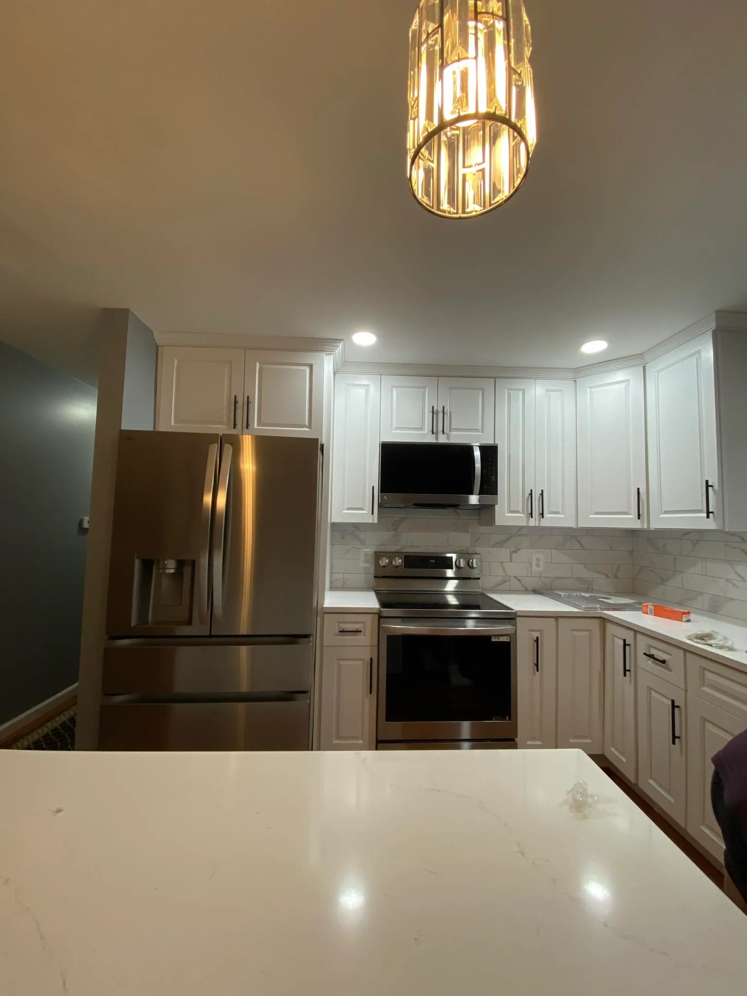 Kitchen with modern crystal chandelier over island