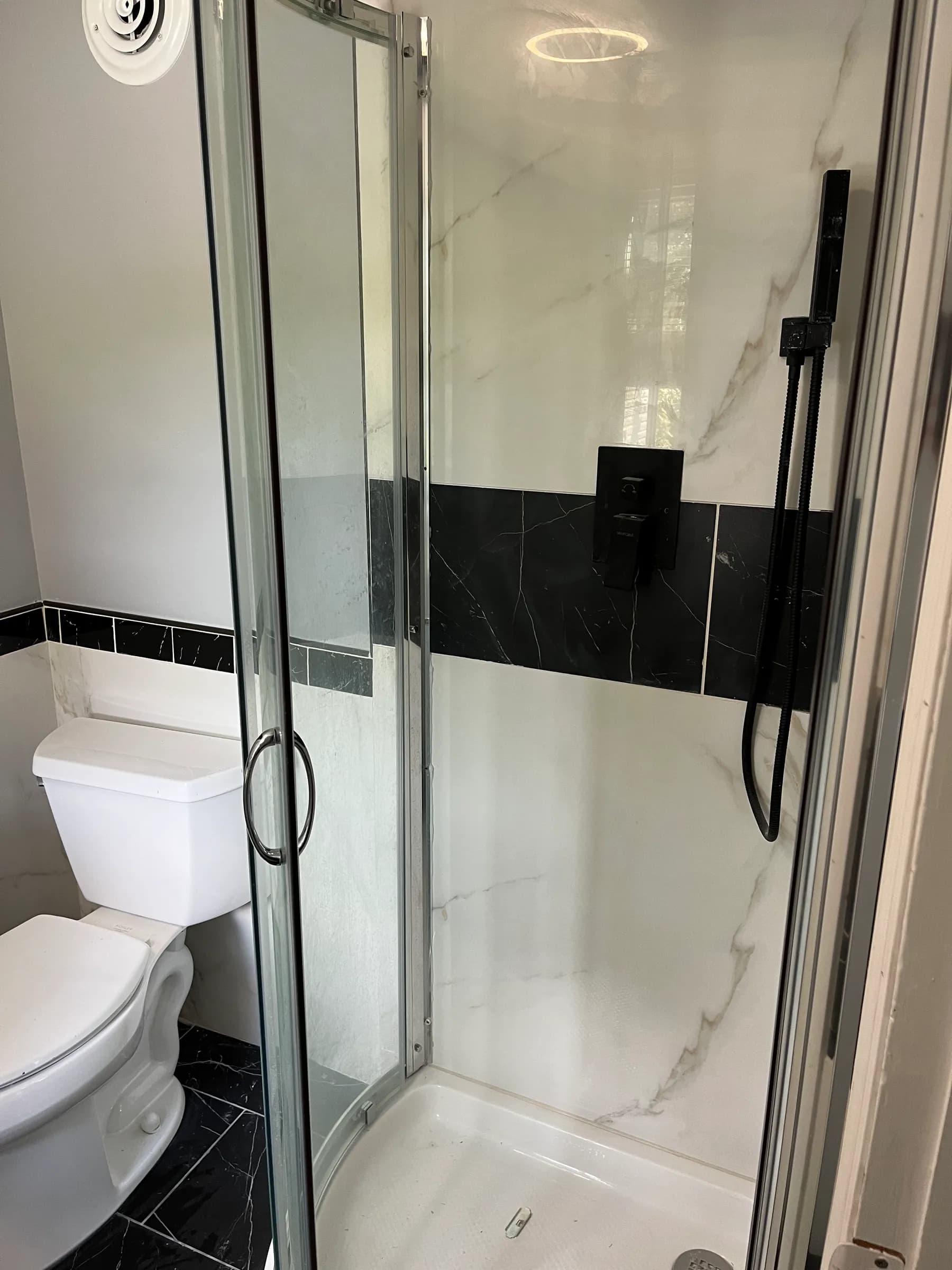 Black marble bathroom interior with toilet and shower