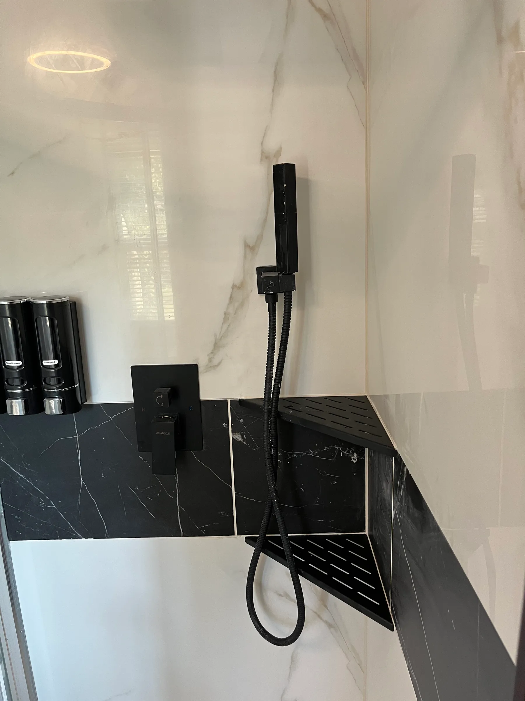 Black marble shower with rainfall and handheld fixture