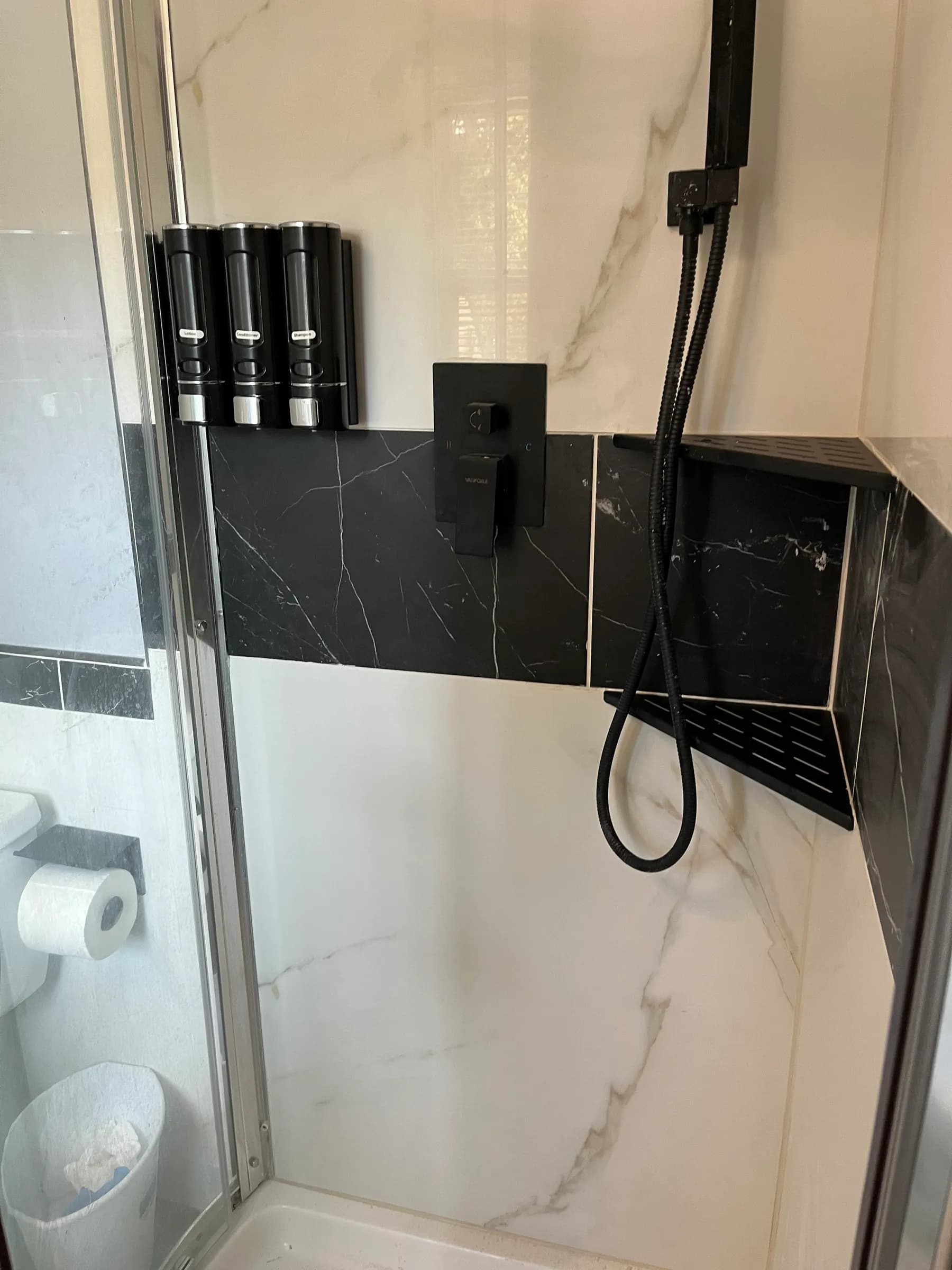 Black marble shower with matte black fixtures detail