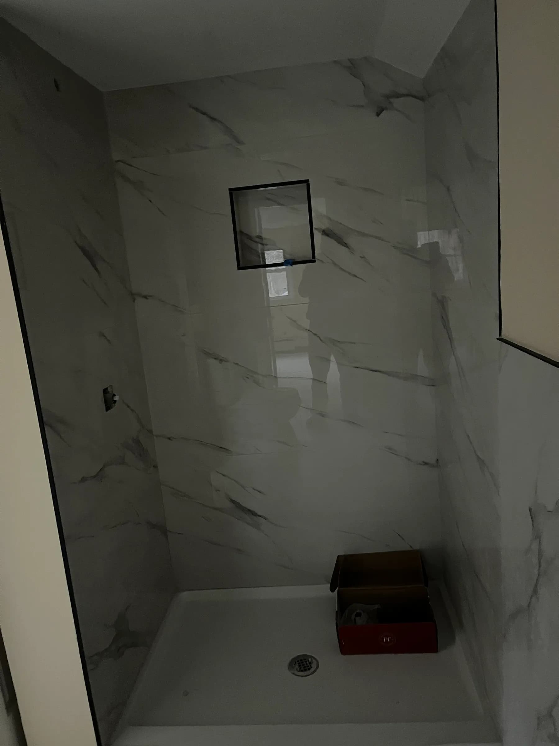 White marble shower with recessed niche