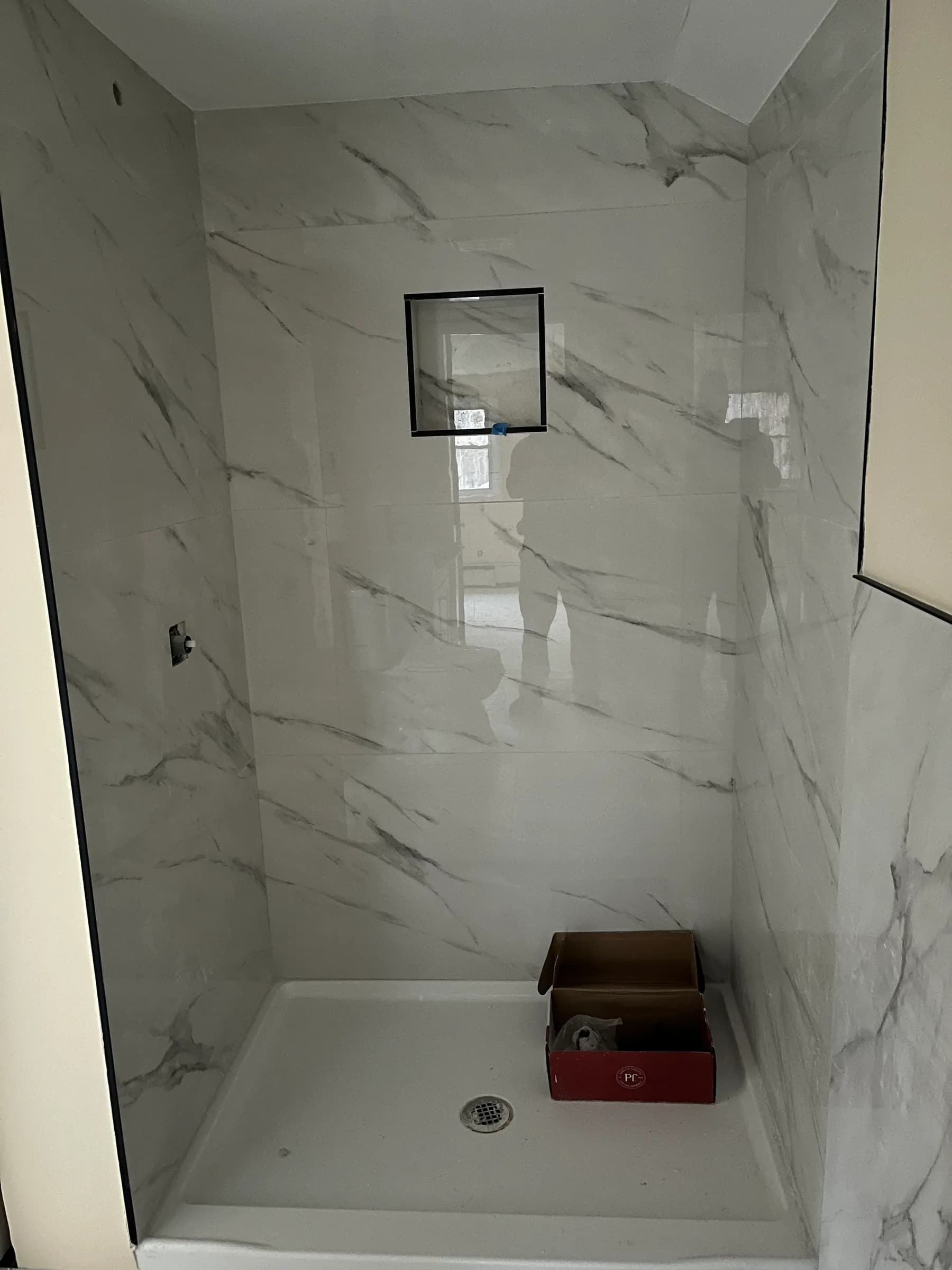 Finished white marble shower walls and niche