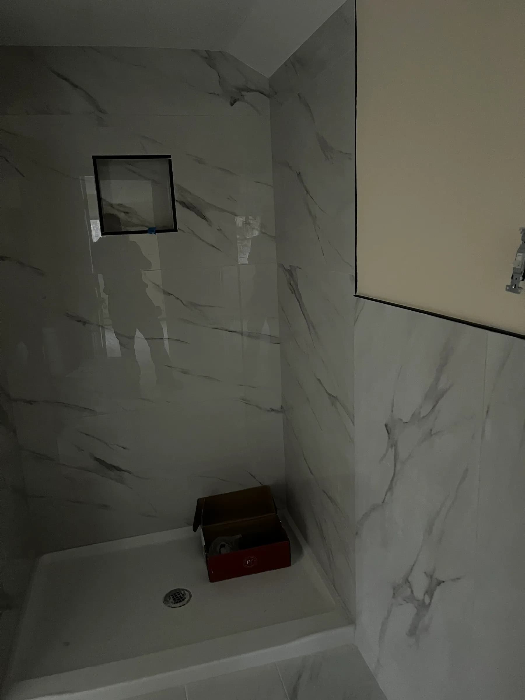 Angled view of marble shower with double niches
