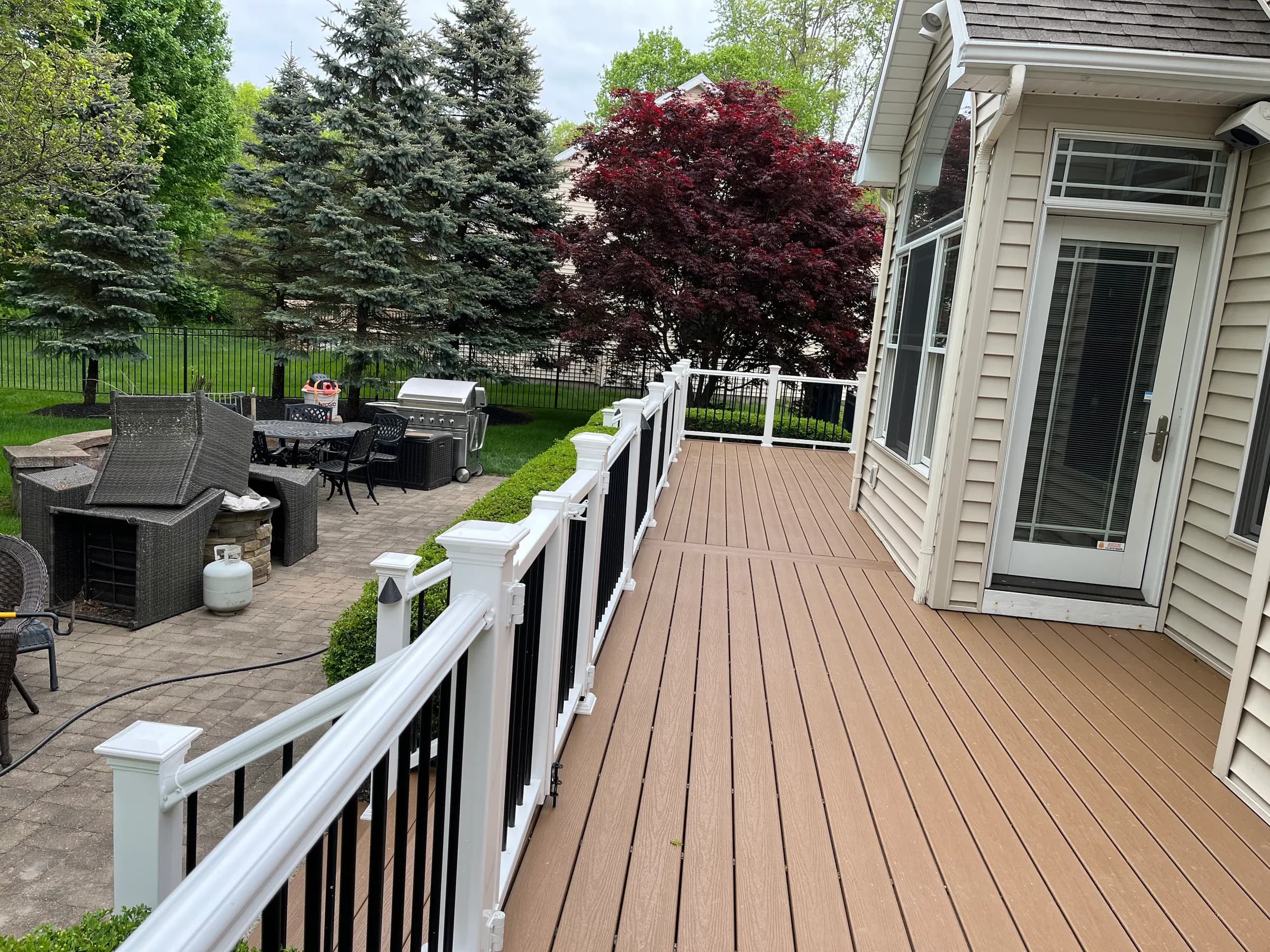 Tan composite deck with grill and patio furniture