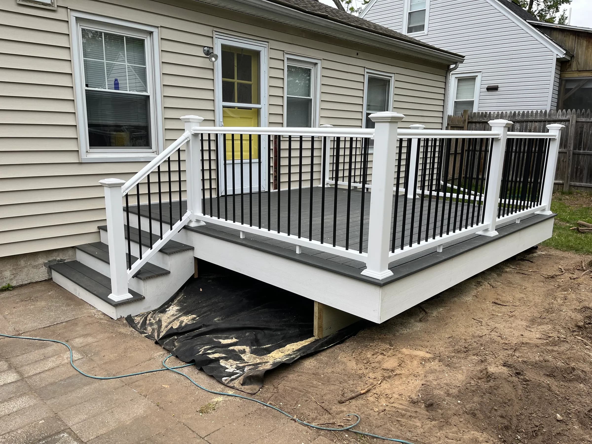 Gray deck at home with yellow front door