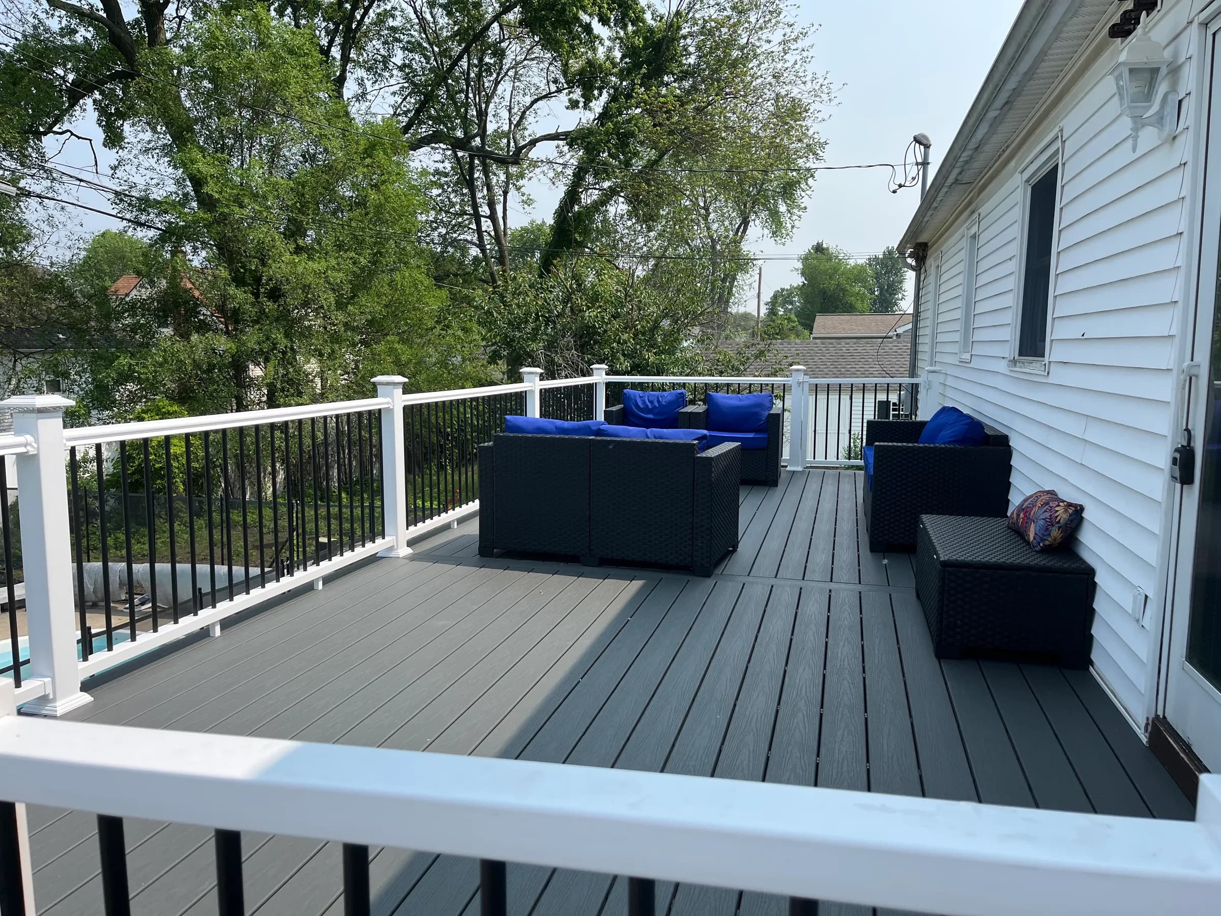 Composite deck with blue cushioned outdoor sectionals and pool
