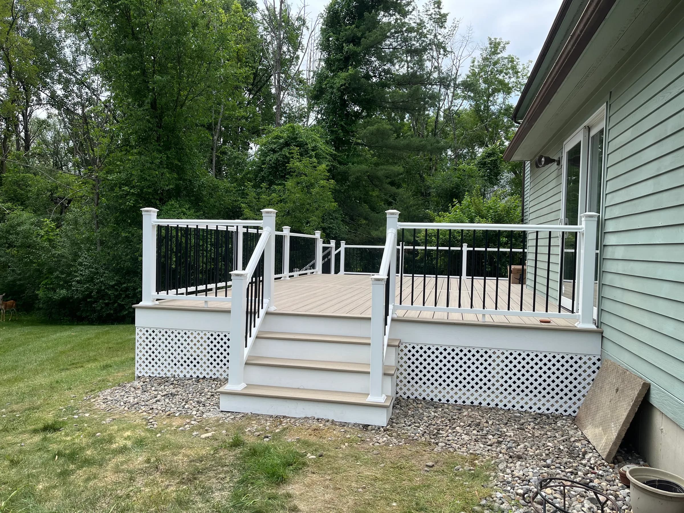 Tan composite deck with white railings and stairs