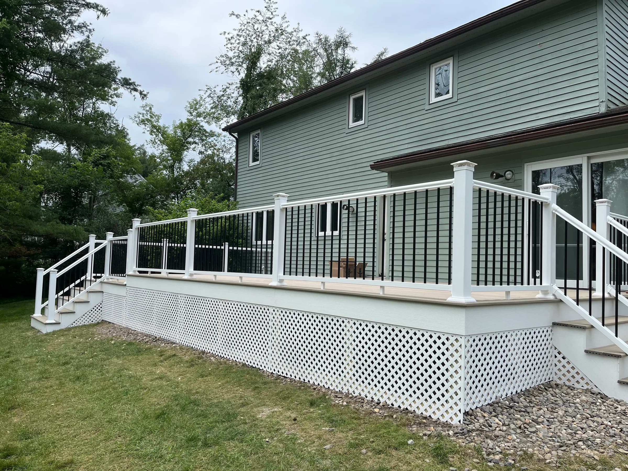 Wider angle of sage green home deck with lattice