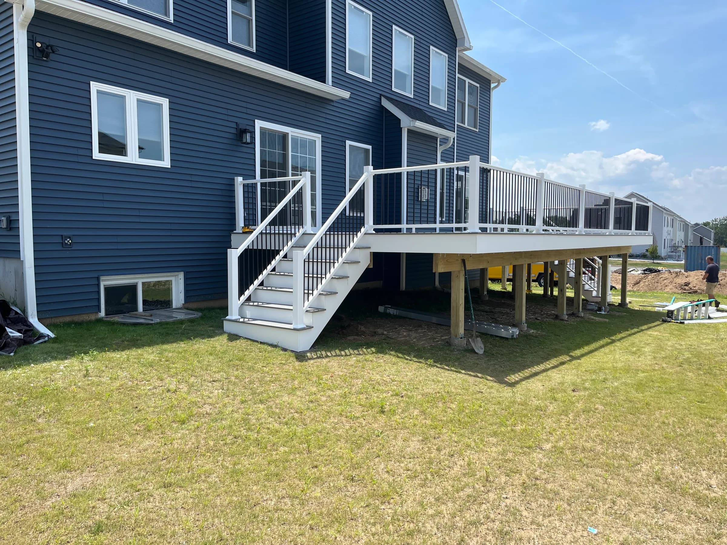 White elevated deck with piers on blue house