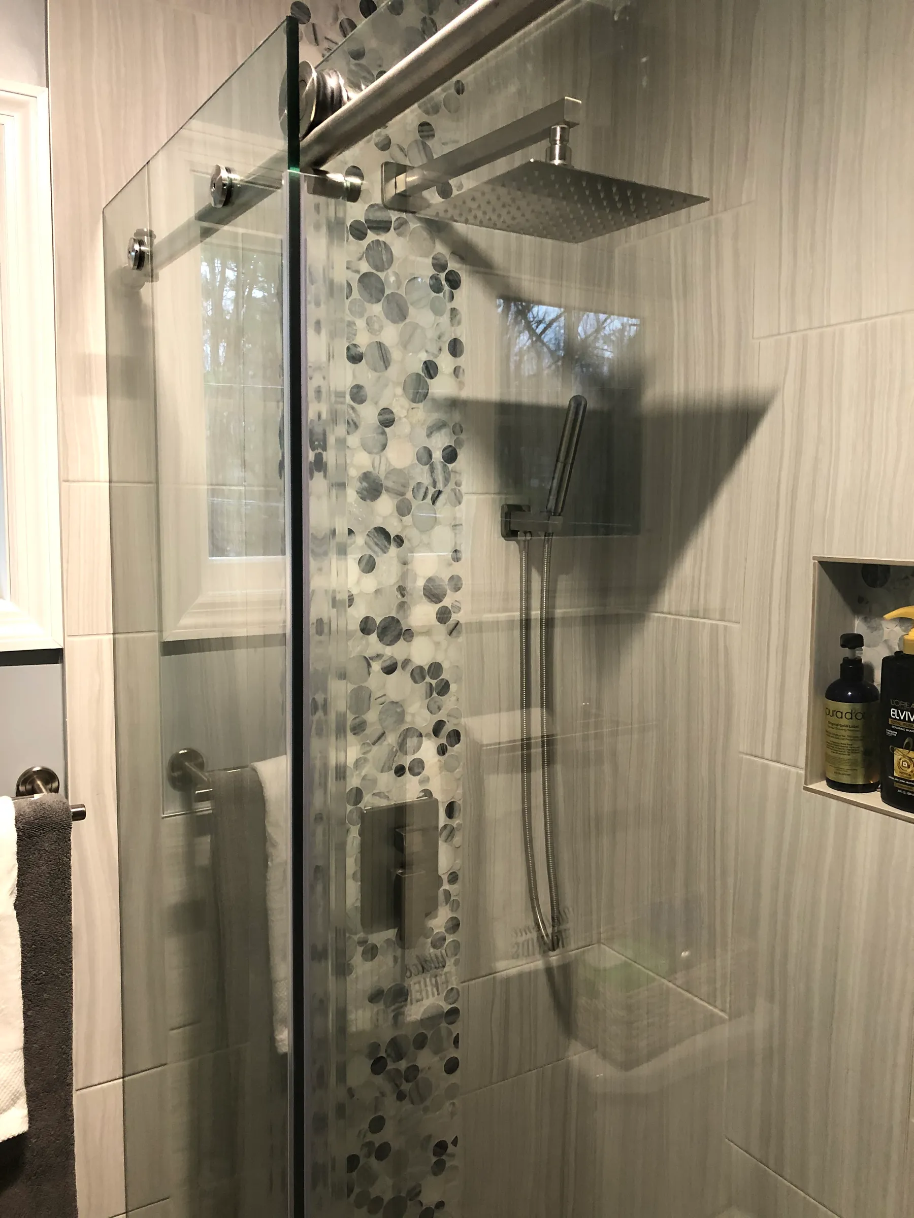 Glass shower with pebble mosaic accent stripe