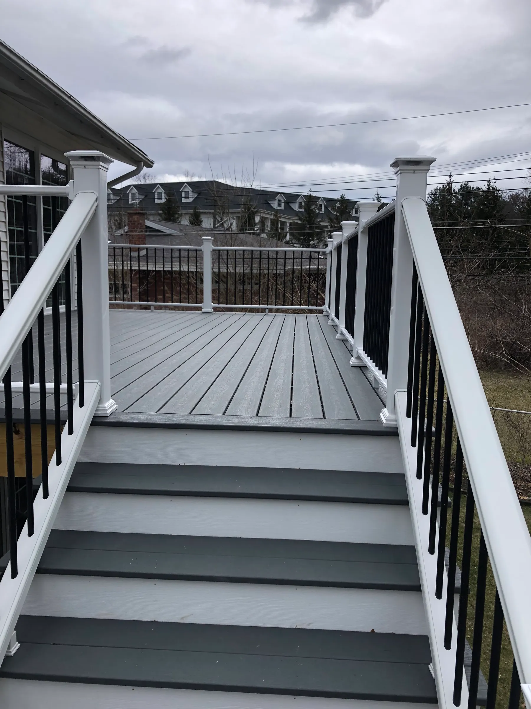 Side view of deck with white rails and gray composite
