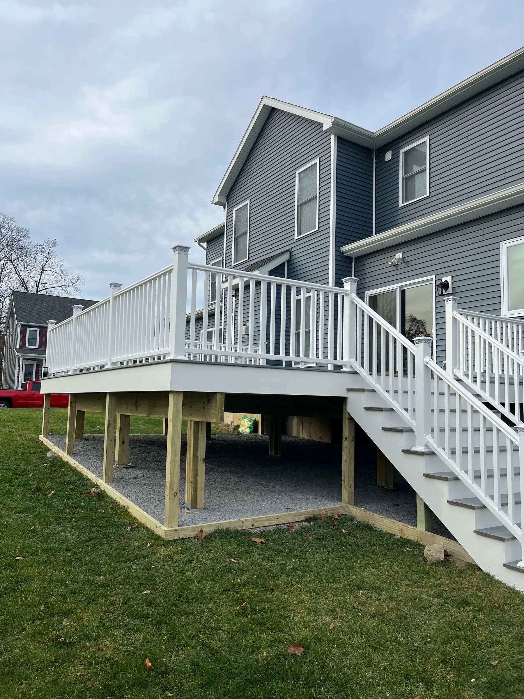 White deck with stairs on gray siding home