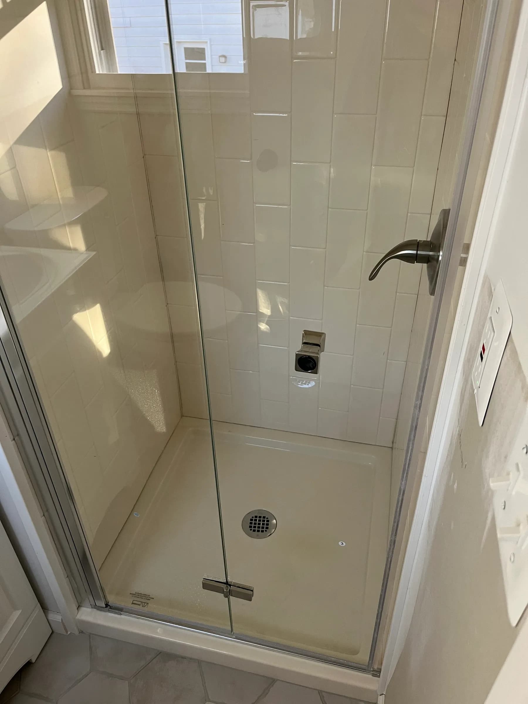 White subway tile shower with glass sliding door